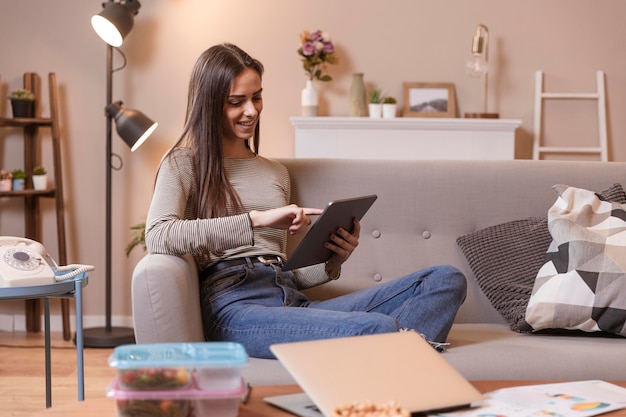 Woman indoors working on digital tablet