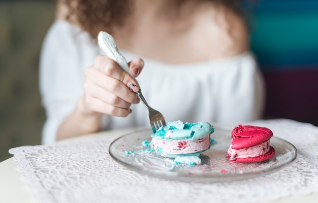 Woman inserting the fork in the ice cream sandwich on plate over the table