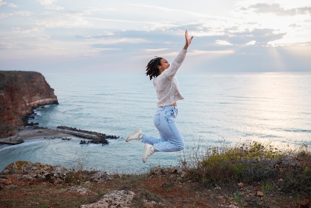 Free photo woman jumping outdoors full shot