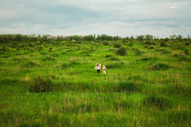 woman in kerchief and man walking in the meadow