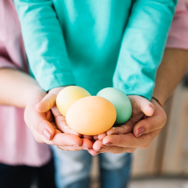 Free photo woman and kid holding easter eggs in hands