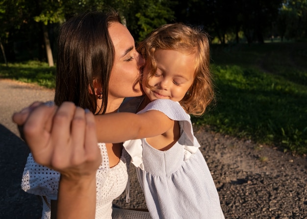 Woman kissing girl on cheek side view