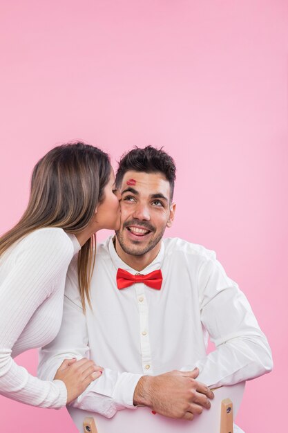 Woman kissing happy man on cheek