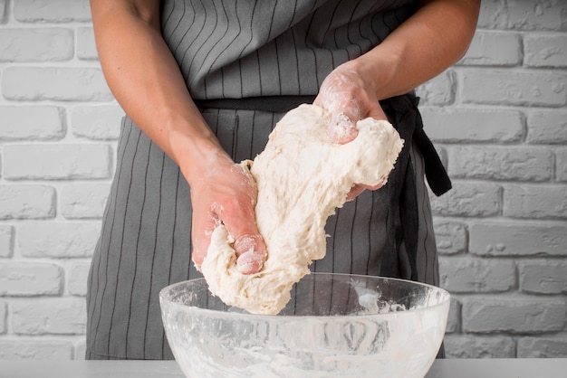 Woman kneading dough over bowl