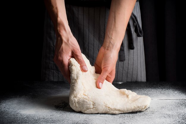 Woman kneading dough on table