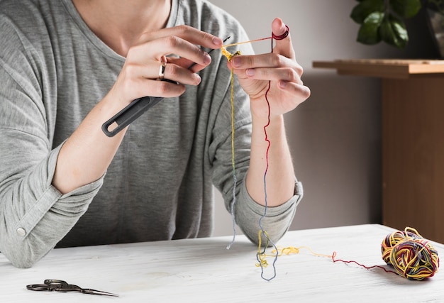 Woman knitting with needle at home