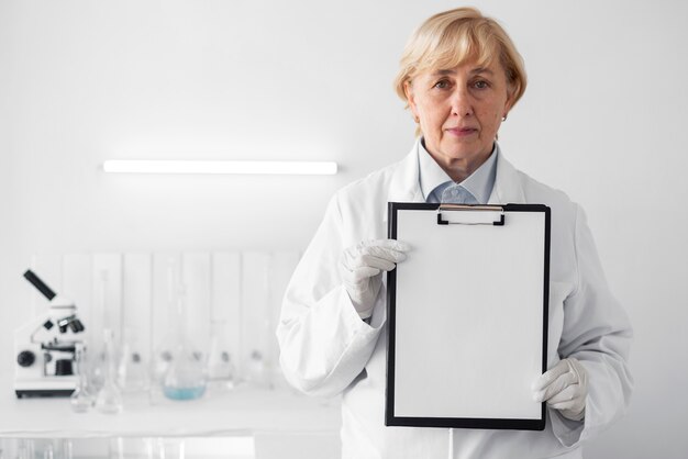 Woman in laboratory showing clipboard