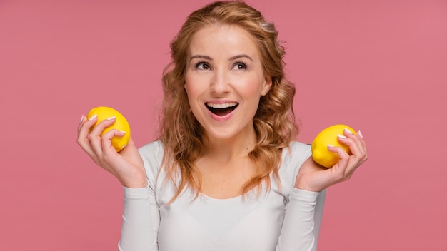 Free photo woman laughing holding lemons