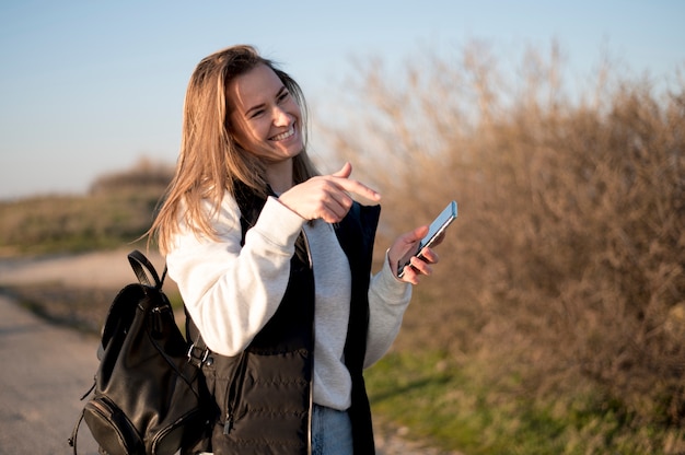 Woman laughing and pointing at her phone