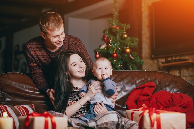 Woman laughing with her baby in her arms while the father looks happy