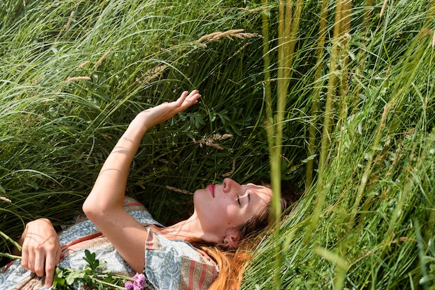 Free photo woman laying on grass high angle