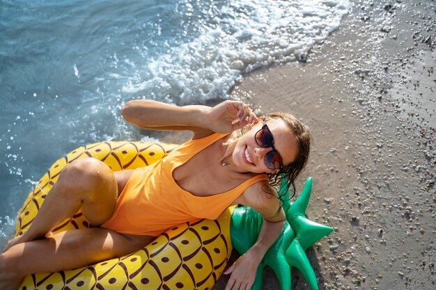 Woman laying on pineapple floater high angle