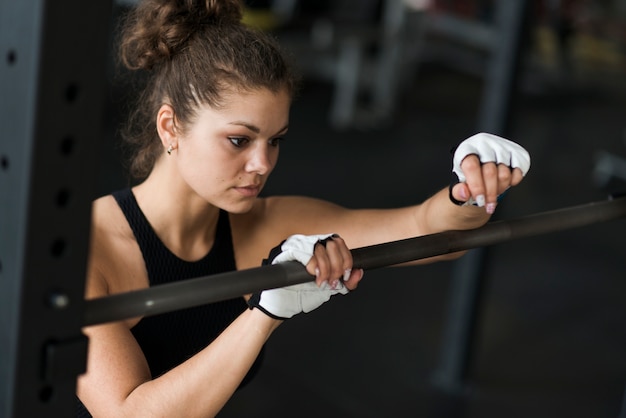 Free Photo woman leaning on bar in gym