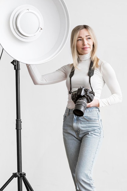 Woman leaning on a studio lamp