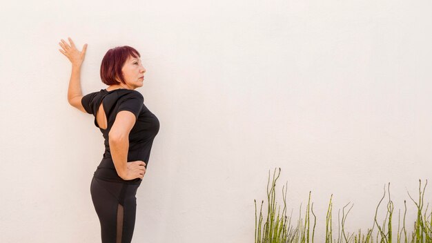 Woman leaning on a wall and stretching