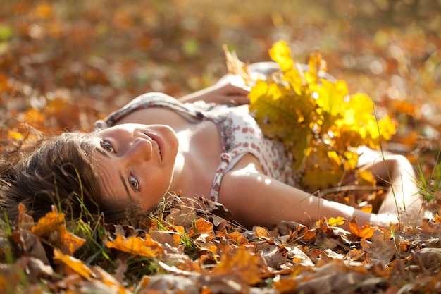 woman lies in oak leaves