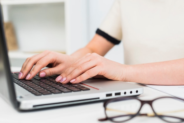 Free photo woman in light typing on laptop keyboard