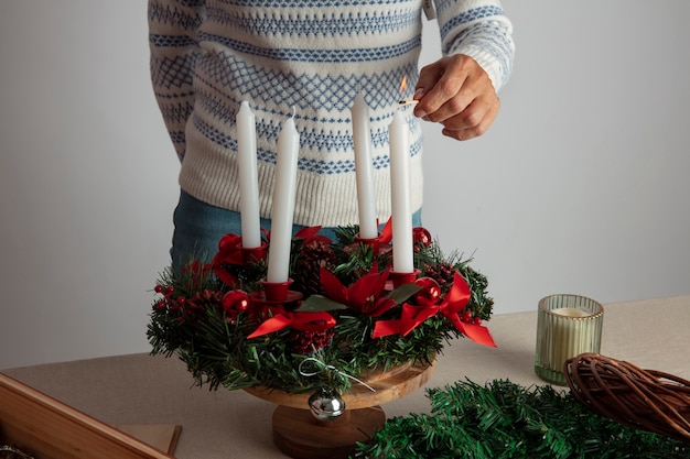 Free Photo woman lighting wreath candle on fire