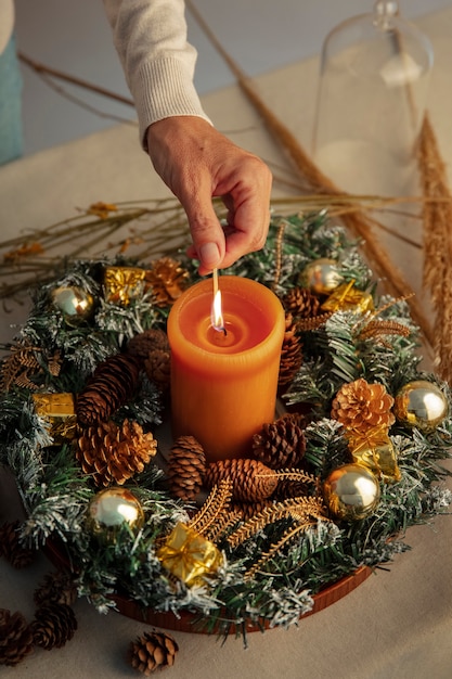 Free photo woman lighting wreath candle on fire