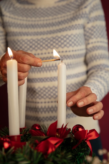 Woman lighting wreath candle on fire