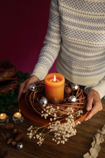 Woman lighting wreath candle on fire