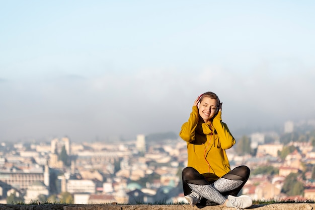 Woman listening to music full shot