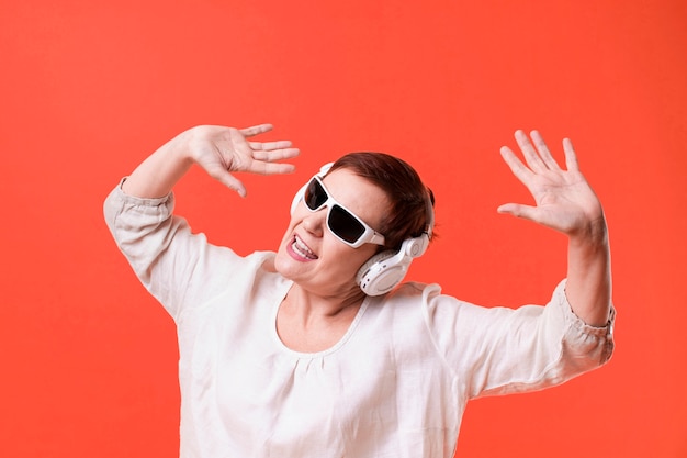 Woman listening music on red background