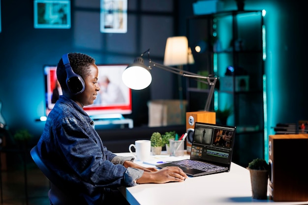 Woman listens to a video on her laptop