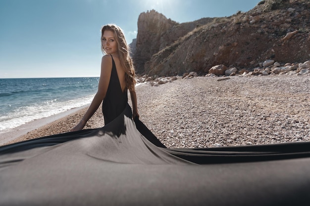 Free photo woman in long black dress near the sea