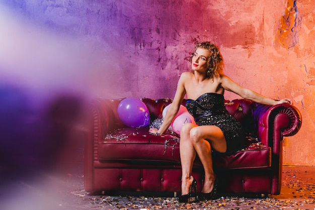 Woman looking away posing on sofa