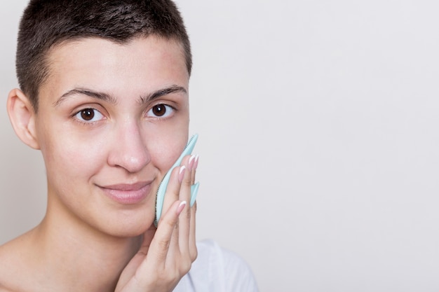 Free Photo woman looking at camera cleaning face