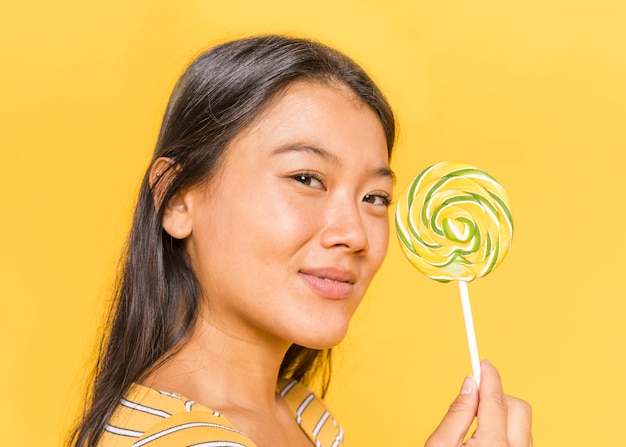 Free Photo woman looking at camera and showing a lollipop