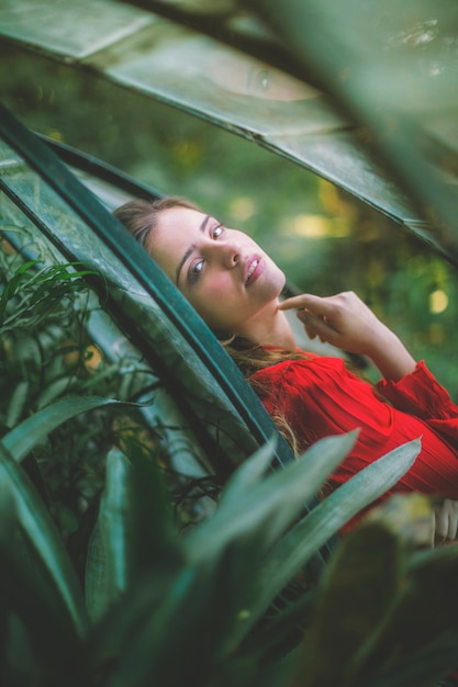 Free photo woman looking at camera through plants