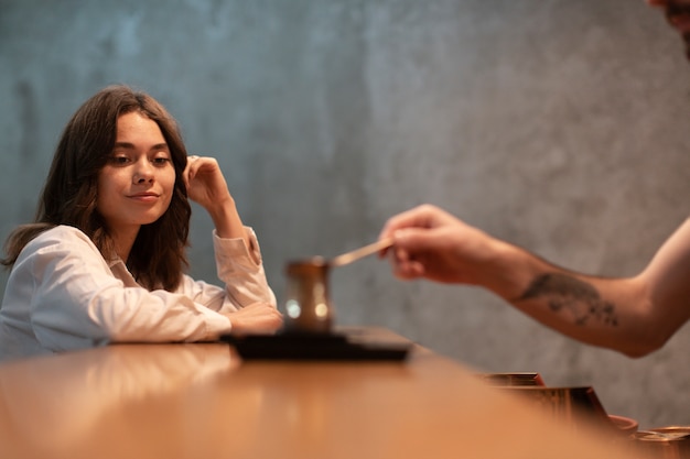 Woman looking at coffee in pot at bar