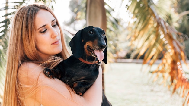 Woman looking at her dog sticking out tongue