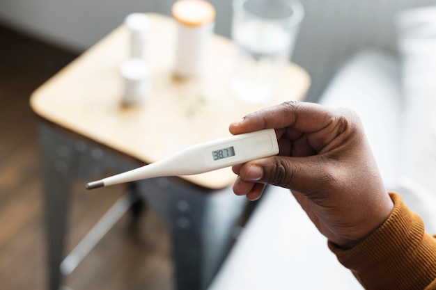 Woman looking at her friend's temperature on a thermometer