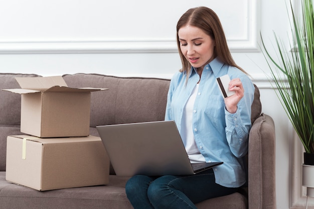 Free photo woman looking at her laptop and holding credit card