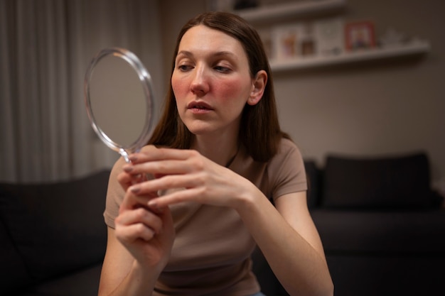 Free Photo woman looking at her rosacea in the mirror