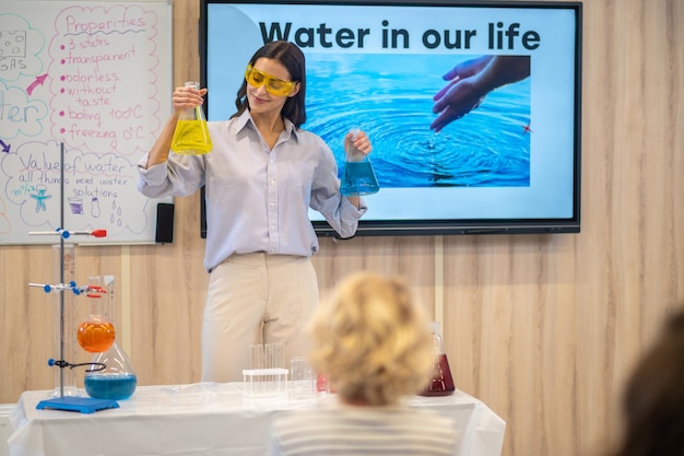 Free Photo woman looking at laboratory flask in hand