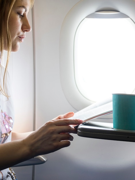 Free photo woman looking at the menu in plane