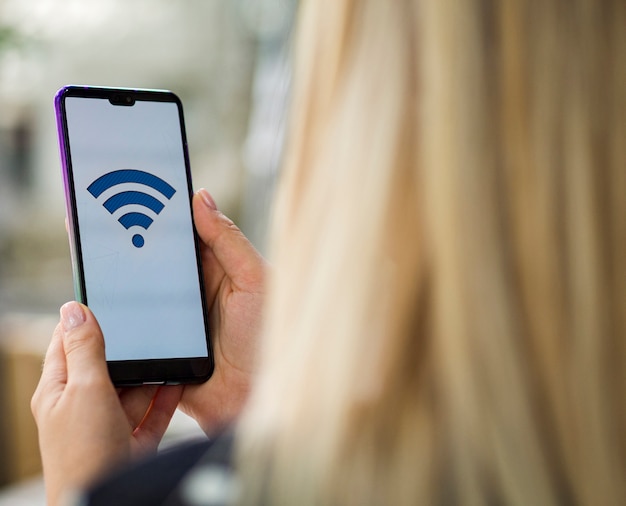 Woman looking at phone screen with wifi logo