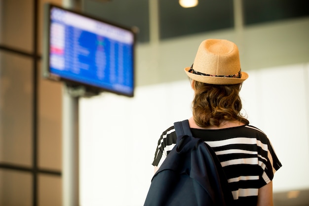 Free photo woman looking screens at the airport