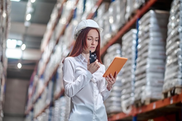 Free photo woman looking at tablet talking on walkie-talkie