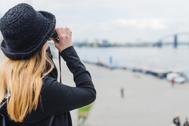 Woman looking at water with binoculars