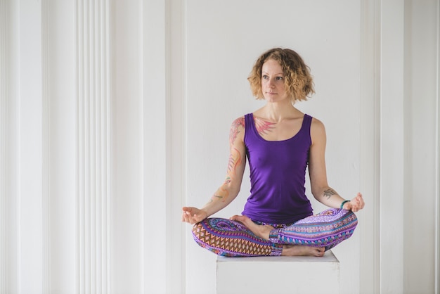 Woman in lotus pose on cube