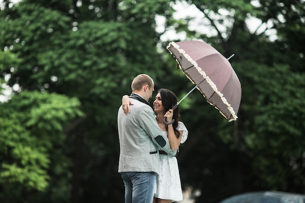 Woman in love with umbrella looking at her boyfriend