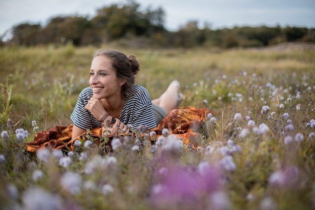 Free Photo woman lying down in a field of flowers during daytime