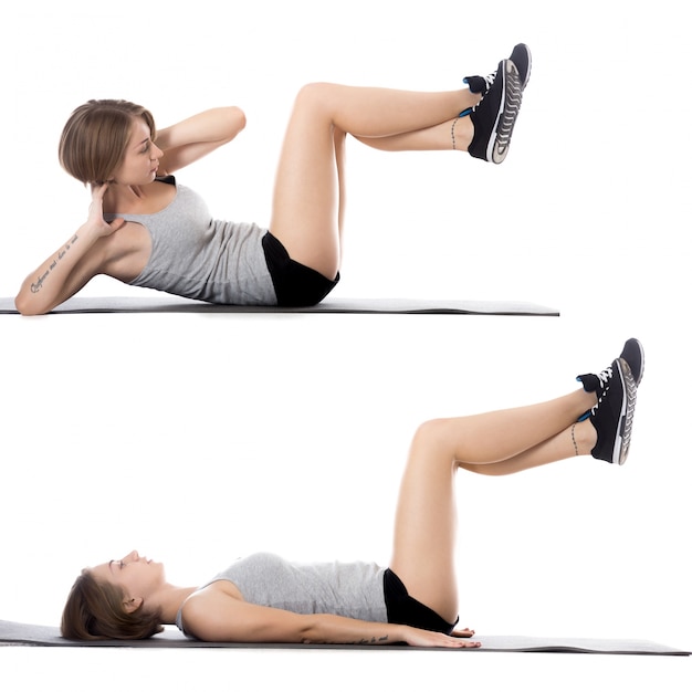 Woman lying on the floor while doing sit-ups