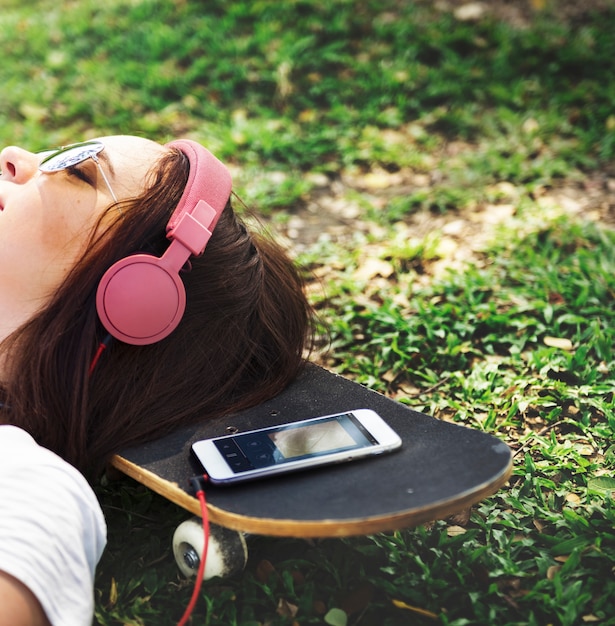 Free photo woman lying on grass listening to music