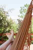 Free photo woman lying in hammock on terrace in summer